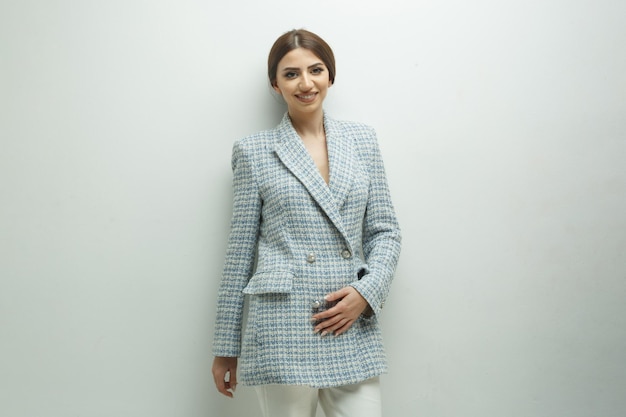 Jeune femme d'affaires portant une veste et souriant sur fond blanc Photo de haute qualité