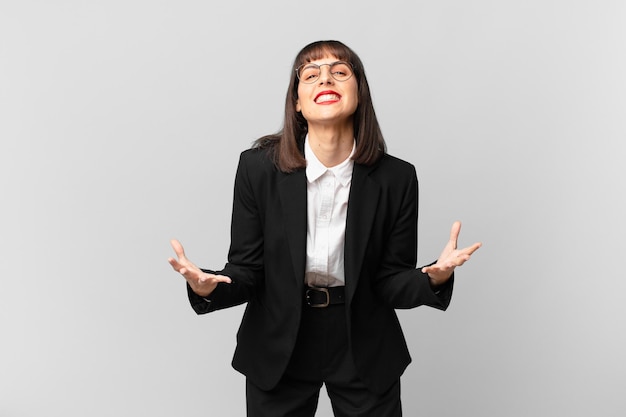 Jeune femme d'affaires qui a l'air en colère, agacée et frustrée de crier wtf ou qu'est-ce qui ne va pas avec vous