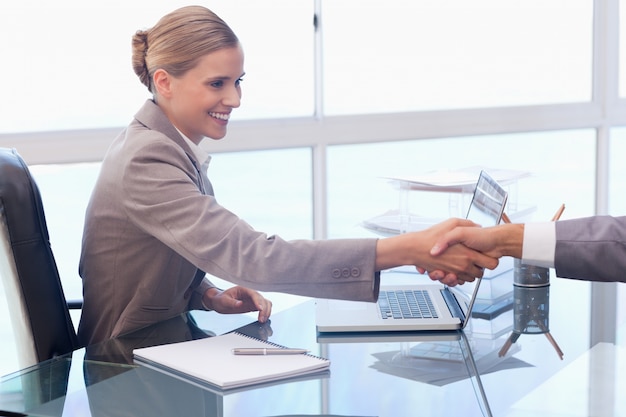 Jeune femme d&#39;affaires recevant un client