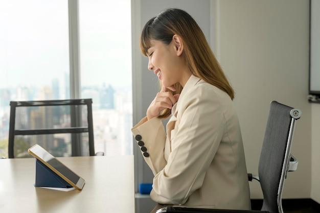 Jeune femme d'affaires regardant l'écran lors d'une réunion d'affaires par vidéoconférence