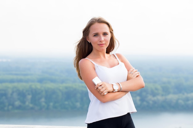 Jeune femme d'affaires regardant avec le sourire à la caméra dans la nature du parc à l'extérieur