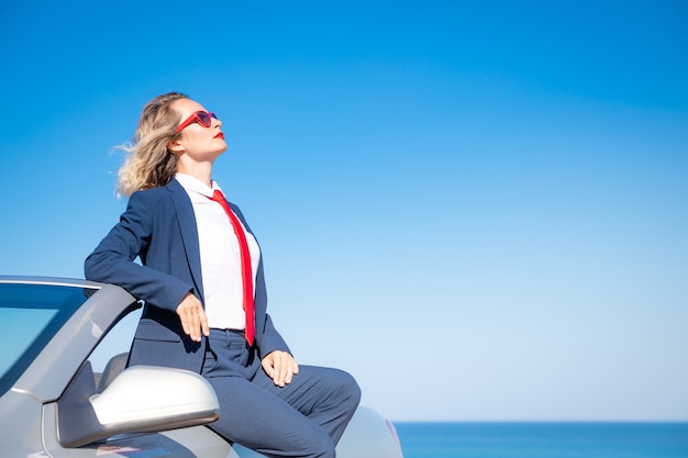 Jeune femme d'affaires réussie sur la plage Femme assise dans la voiture classique cabriolet