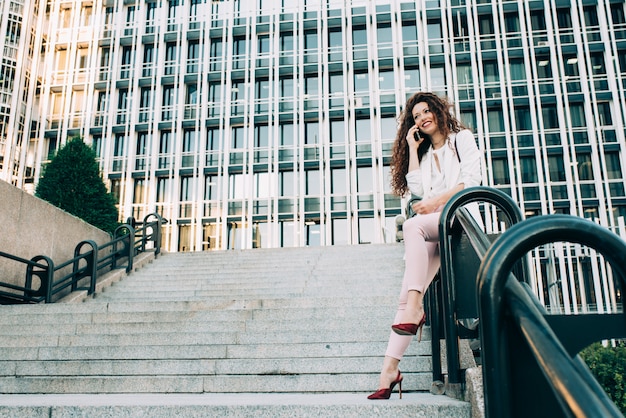 Jeune femme d'affaires rousse marchant dans les escaliers