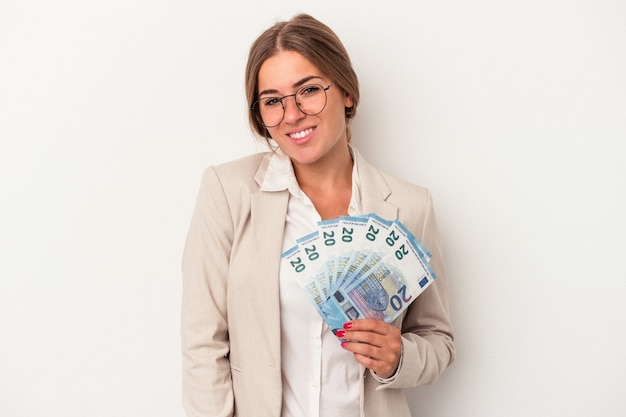 Jeune femme d'affaires russe tenant des billets isolés sur fond blanc heureux, souriant et joyeux.