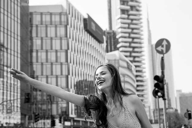 Jeune femme d'affaires souriante hélant un taxi. Attrapez un taxi dans la rue de la ville. Concept de voyage, de tourisme et de personnes. Vie citadine, temps de pointe.