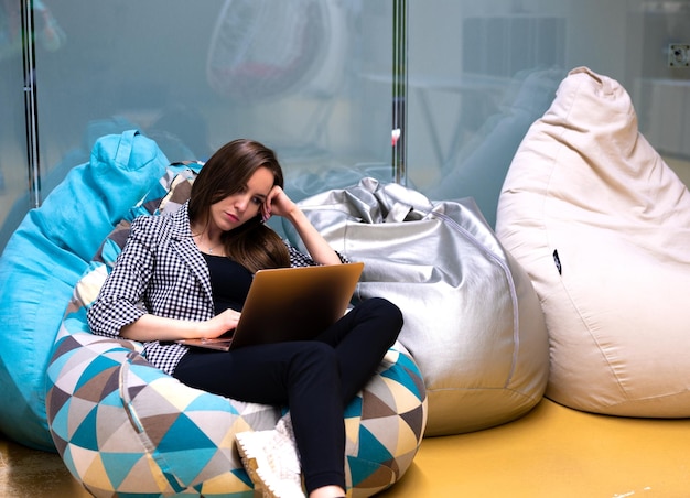 Une jeune femme d'affaires souriante et satisfaite a fermé les yeux de plaisir, se détend après le travail terminé