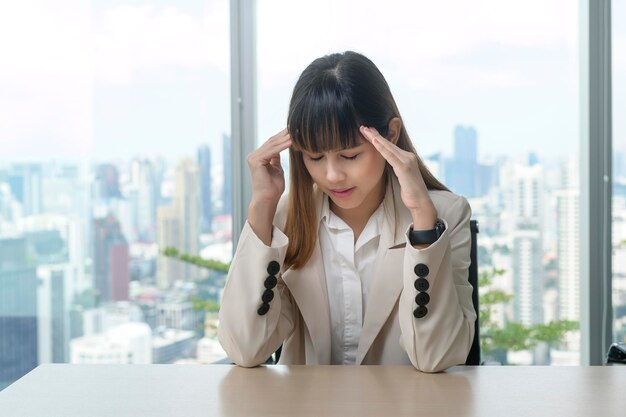 Jeune femme d'affaires stressée et fatiguée dans un bureau moderne