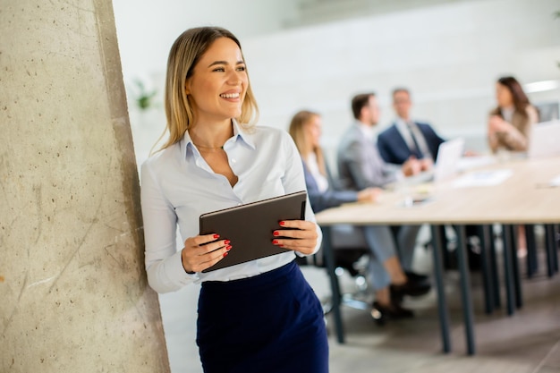 Jeune femme d'affaires avec tablette numérique au bureau