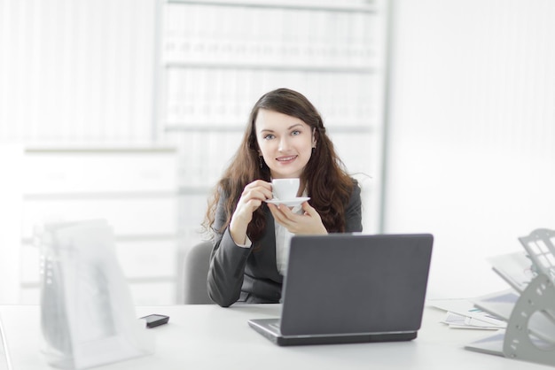 Jeune femme d'affaires avec une tasse de café pendant une pause de travail