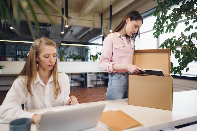 Jeune femme d'affaires tenant une boîte d'effets personnels sur le point de quitter ses fonctions après avoir quitté son emploi