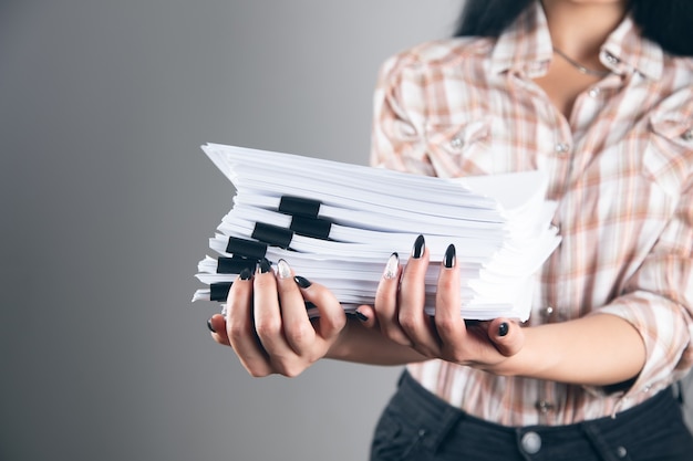 Jeune femme d'affaires tenant une pile de papiers