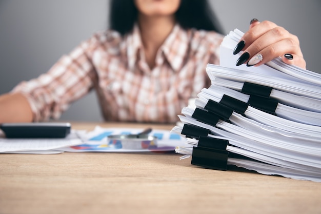 Jeune femme d'affaires tenant une pile de papiers