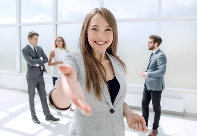 Jeune femme d'affaires tendant la main pour une poignée de main concept de partenariat