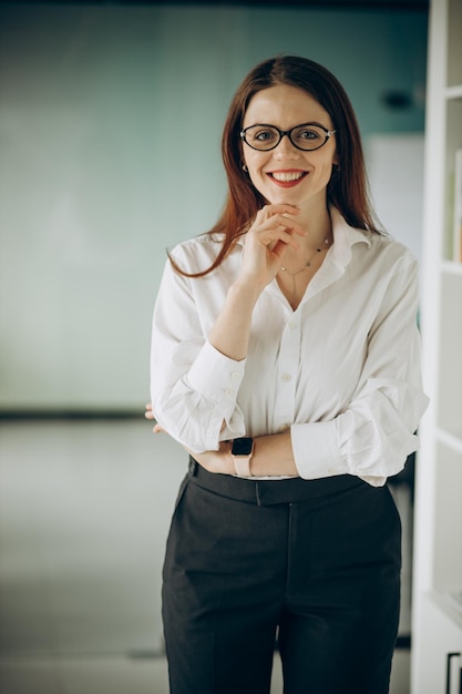 Jeune femme d'affaires en tenue de soirée debout au bureau