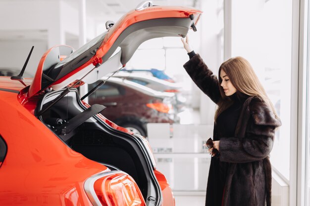 Une jeune femme d'affaires teste des voitures dans un magasin de voitures