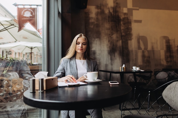 Jeune femme d'affaires travaillant dans un café