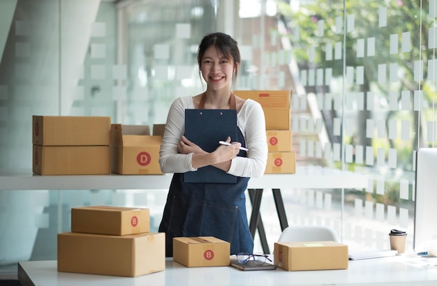 Jeune femme d'affaires travaillant dans le commerce électronique en ligne dans son magasin Jeune vendeuse prépare une boîte de colis de produit à livrer au client Vente en ligne ecommercexA