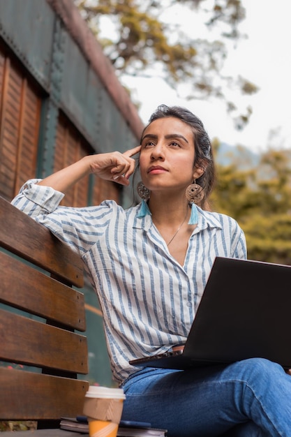 Jeune femme d'affaires travaillant à l'extérieur tout en réfléchissant aux informations qu'elle lit Concept de femme d'affaires