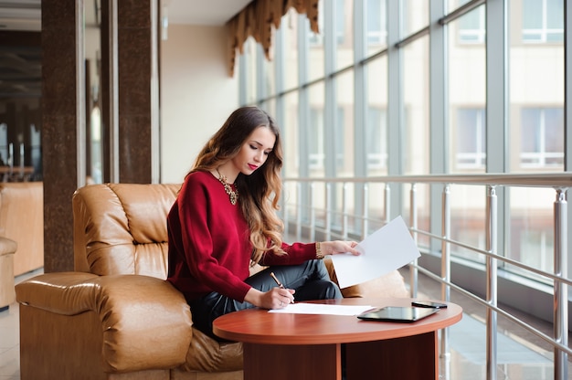 Jeune femme d'affaires travaillant sur un ordinateur portable en attendant son flig
