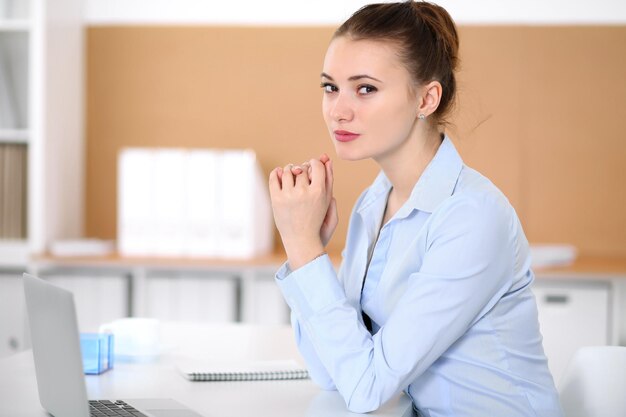 Jeune femme d'affaires travaillant sur ordinateur portable au bureau. Concept d'entreprise réussi.