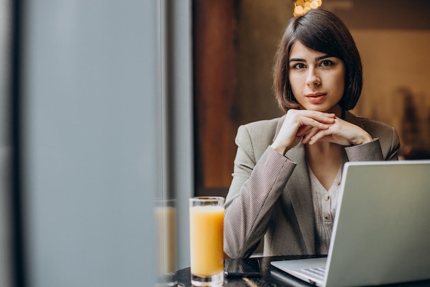 Jeune femme d'affaires travaillant sur un ordinateur portable dans un café