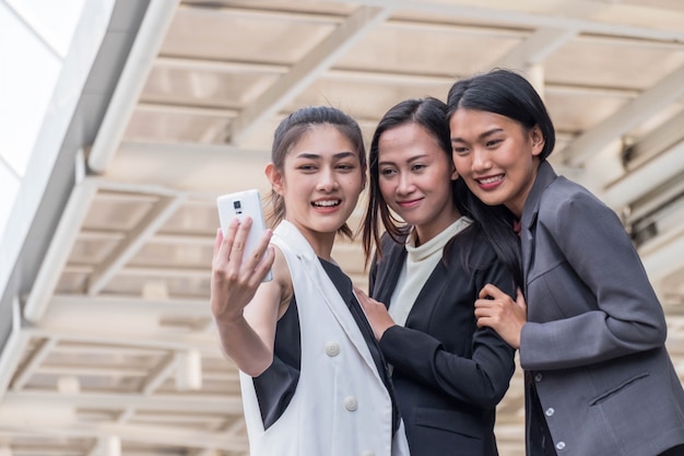 Jeune femme d'affaires travaillant en plein air prenant un selfie