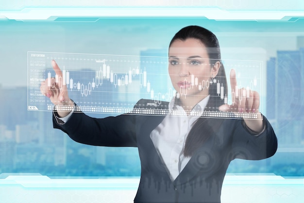 Jeune femme d'affaires travaille avec une interface graphique virtuelle dans un bureau futuriste