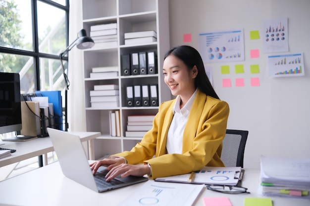 Une jeune femme d'affaires travaille sur un ordinateur portable au bureau.