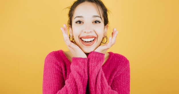 Jeune femme africaine avec de belles dents souriant à la caméra positivement et en toute confiance à l'air satisfait posant isolé sur fond de mur de couleur jaune Expressions quotidiennes avec espace de copie en studio