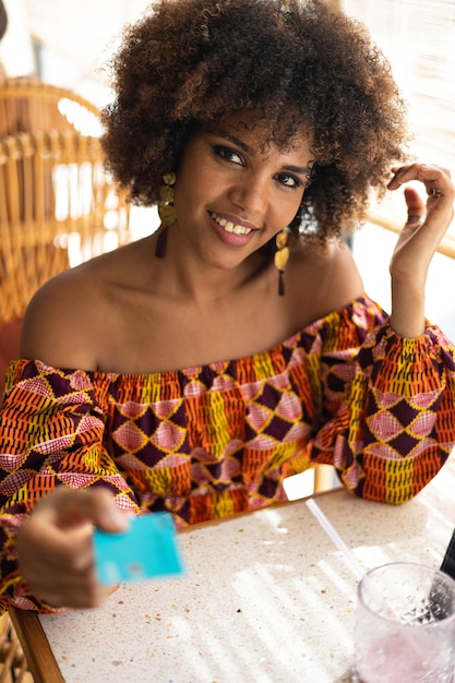 Jeune femme africaine avec carte de crédit pour payer au restaurant