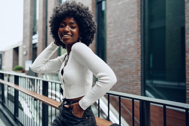 Jeune femme africaine debout sur la rue de la ville à l'extérieur