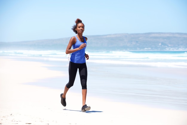 Jeune femme africaine, faire du jogging le long de la côte de la mer