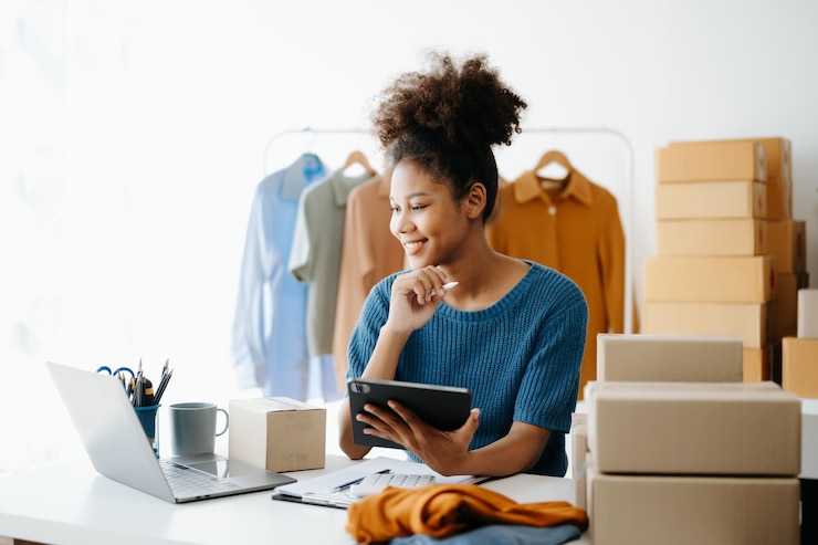 Photo jeune femme africaine gérant un magasin en ligne startup petite entreprise pme utilisant un smartphone ou une tablette recevant et vérifiant la commande d'achat en ligne au bureau