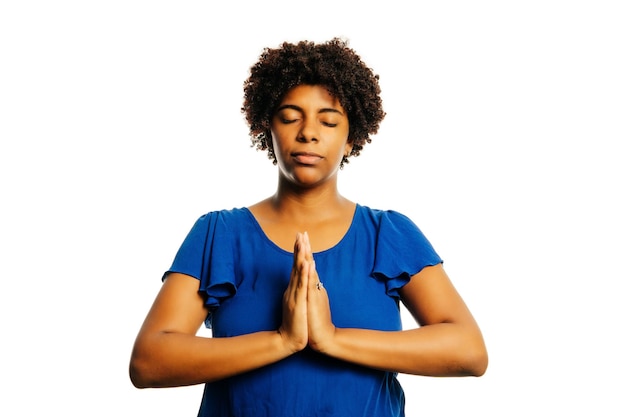 Une jeune femme africaine pratiquant des exercices de yoga de respiration sur un fond blanc isolé