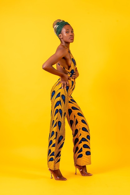 Photo jeune femme africaine en studio sur un costume traditionnel de fond jaune