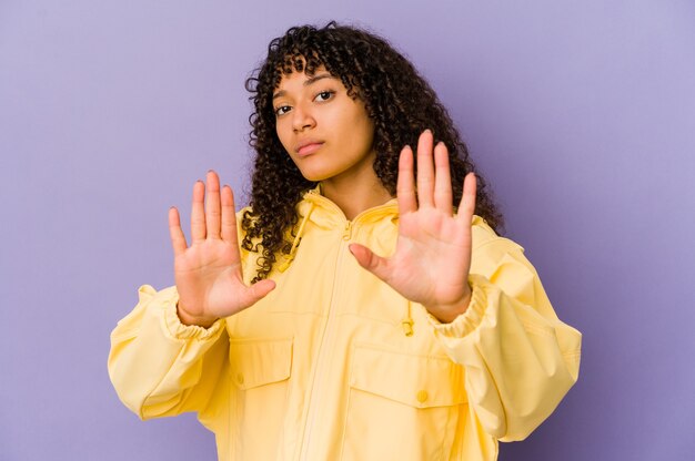 Jeune femme afro-américaine afro-américaine isolée debout avec la main tendue montrant le panneau d'arrêt, vous empêchant.