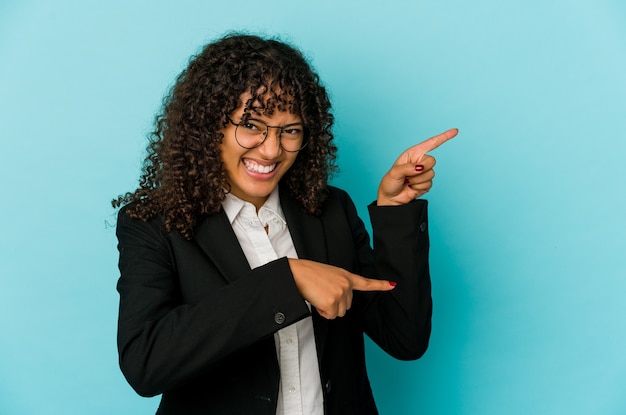 Jeune femme afro-américaine afro-américaine isolée excitée pointant avec l'index loin.