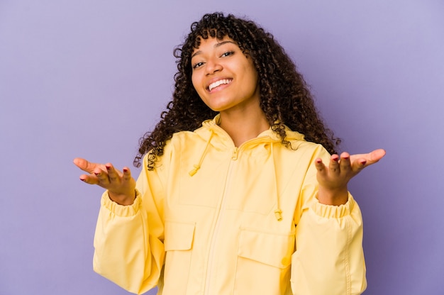 Jeune femme afro-américaine afro-américaine isolée montrant une expression de bienvenue.