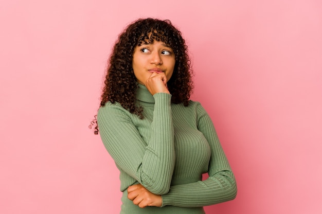 Jeune femme afro-américaine afro-américaine isolée à la recherche de côté avec une expression douteuse et sceptique.