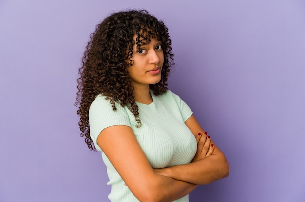 Jeune femme afro-américaine afro-américaine isolée suspecte, incertaine, vous examinant.