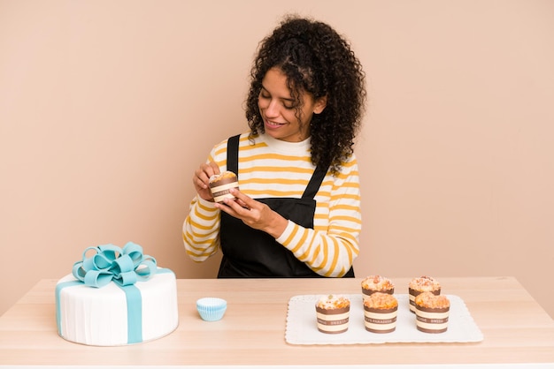 Jeune femme afro-américaine apprenant à faire des muffins et des gâteaux sucrés