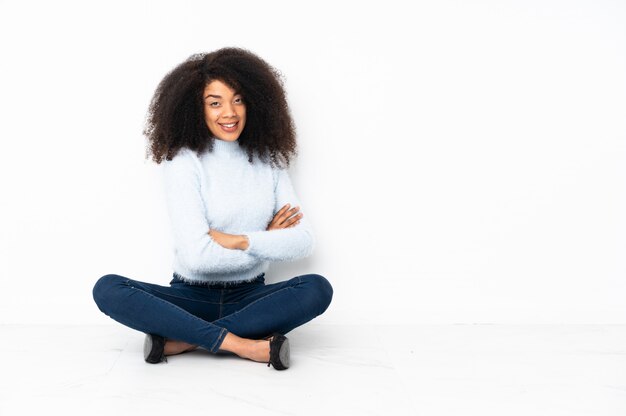 Jeune femme afro-américaine, assis sur le sol avec les bras croisés et impatient