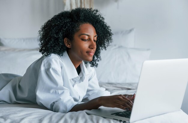 Jeune femme afro-américaine aux cheveux bouclés à l'intérieur à la maison