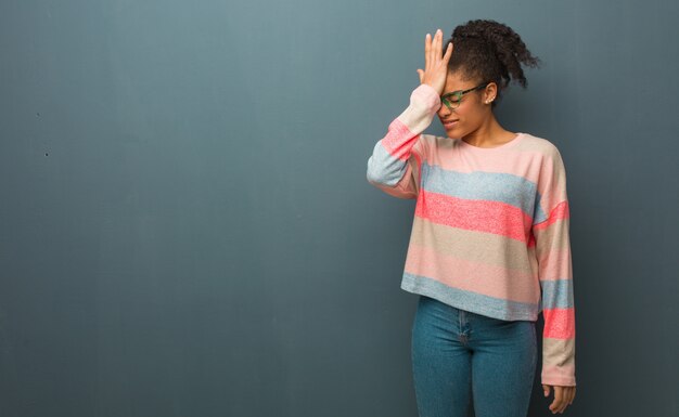 Jeune femme afro-américaine aux yeux bleus oublieux, réaliser quelque chose