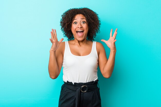 Jeune femme afro-américaine célébrant une victoire ou un succès, il est surpris et choqué.