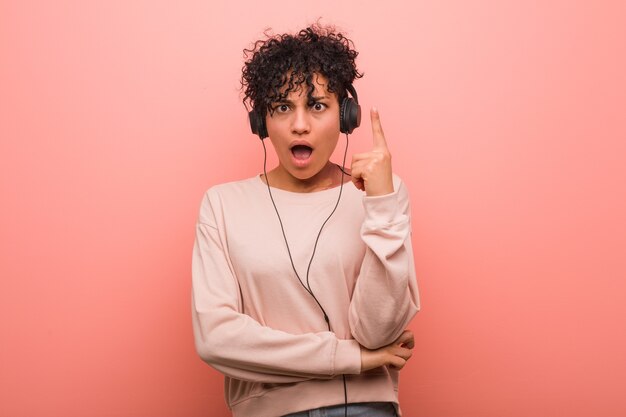 Jeune femme afro-américaine écoutant de la musique ayant une excellente idée, concept de créativité.