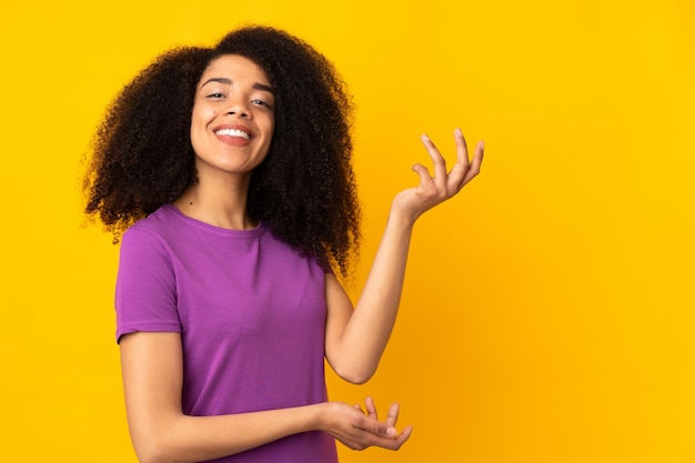 Jeune femme afro-américaine étendant les mains sur le côté pour inviter à venir