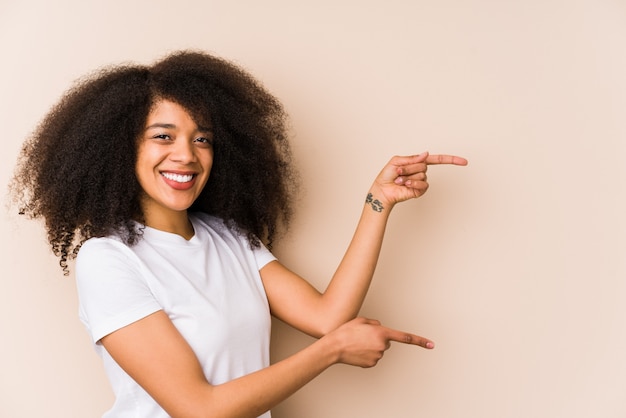 Jeune femme afro-américaine excitée pointant avec les index loin.