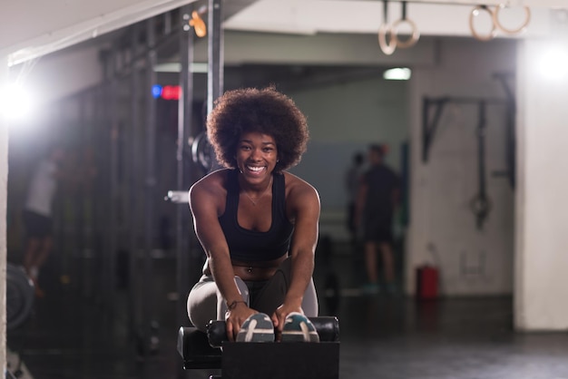 Jeune femme afro-américaine en forme faisant des redressements assis dans un studio de remise en forme à la salle de sport.Exercices abdominaux