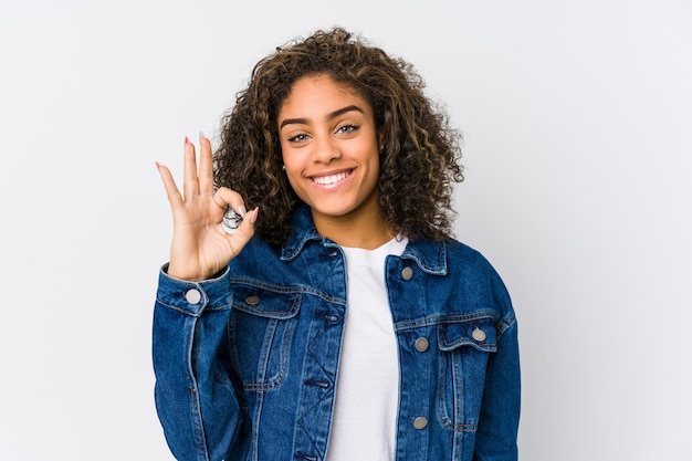 Jeune femme afro-américaine gaie et confiante montrant le geste ok.